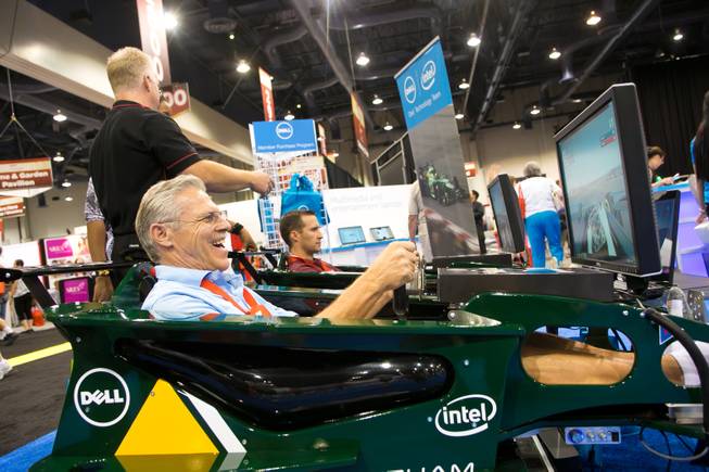 Bob Scheuerell of Buckeye, Ariz., smiles as he drives a Formula One simulator at the Dell computers booth during the 2013 AARP Convention on Thursday, May 30, 2013.